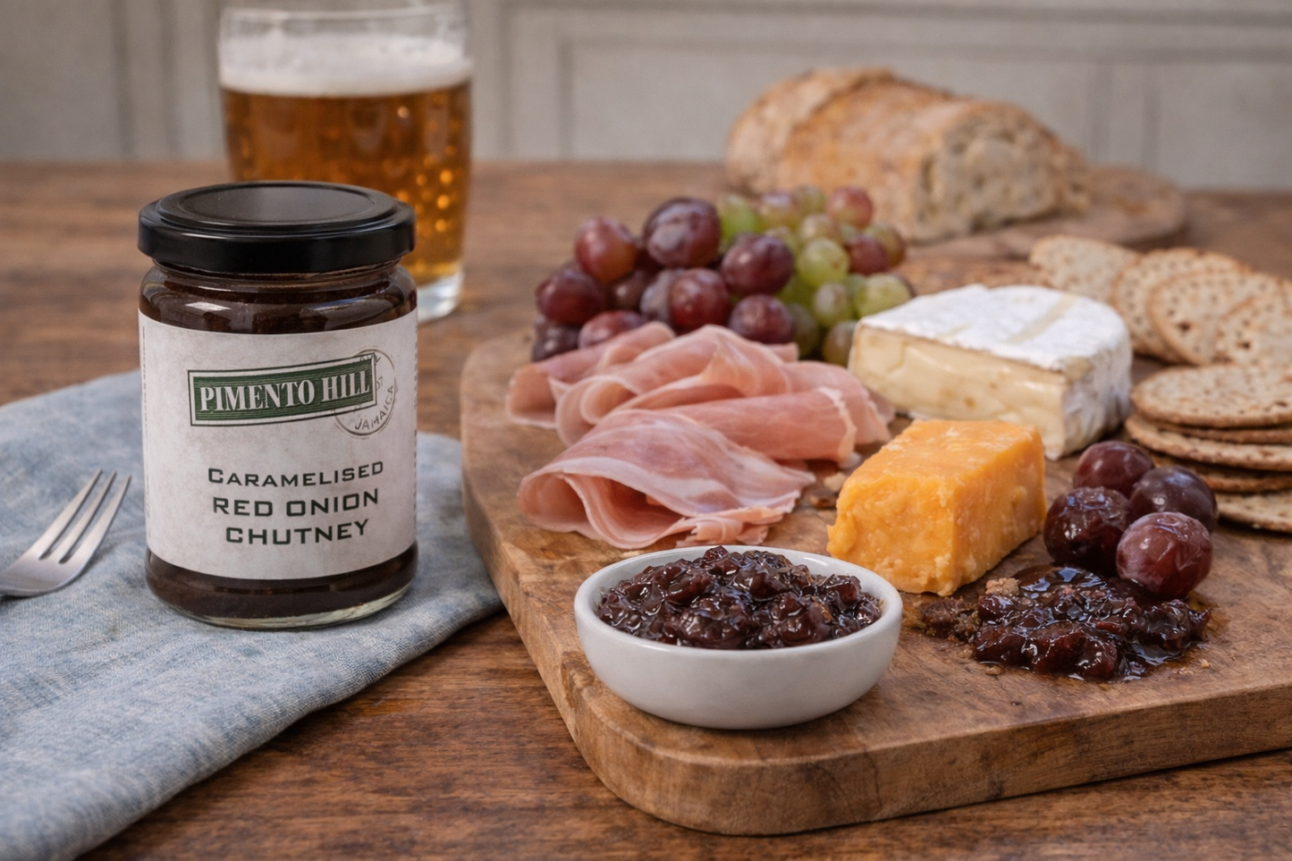 Pimento Hill caramelised red onion chutney served with cheese, charcuterie, crackers and grapes on a rustic cheeseboard.